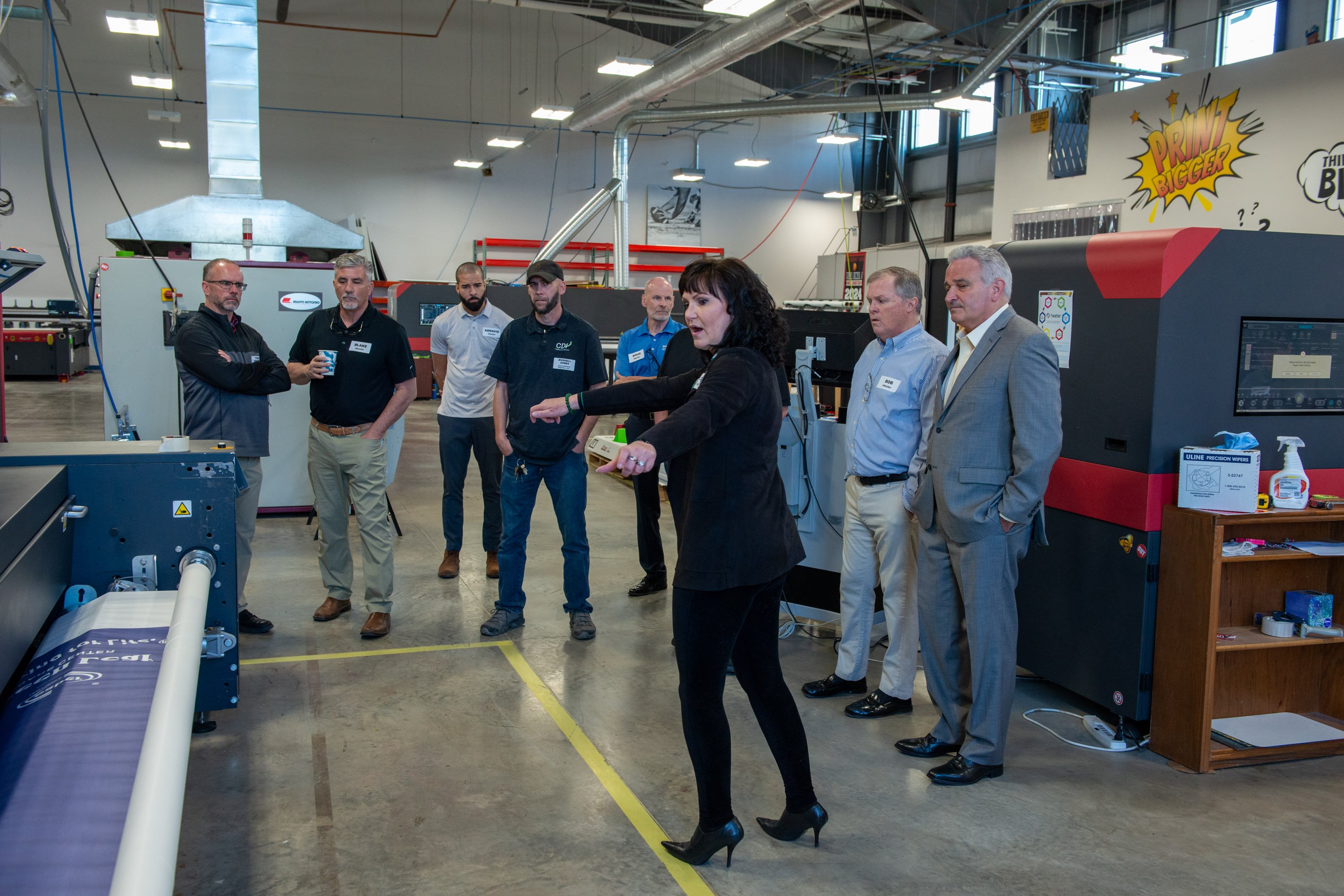 Heeter team in room looking at printing machine.